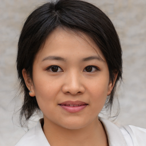 Joyful asian child female with medium  brown hair and brown eyes