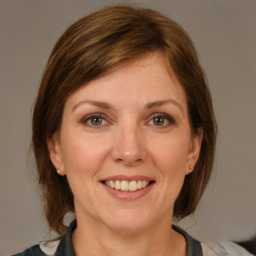 Joyful white adult female with medium  brown hair and grey eyes