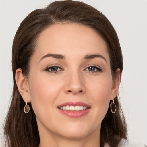 Joyful white young-adult female with long  brown hair and grey eyes