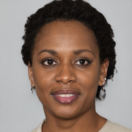 Joyful black young-adult female with short  black hair and brown eyes