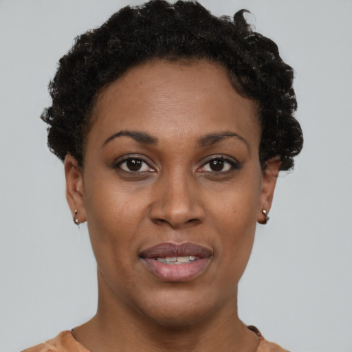 Joyful black young-adult female with short  brown hair and brown eyes
