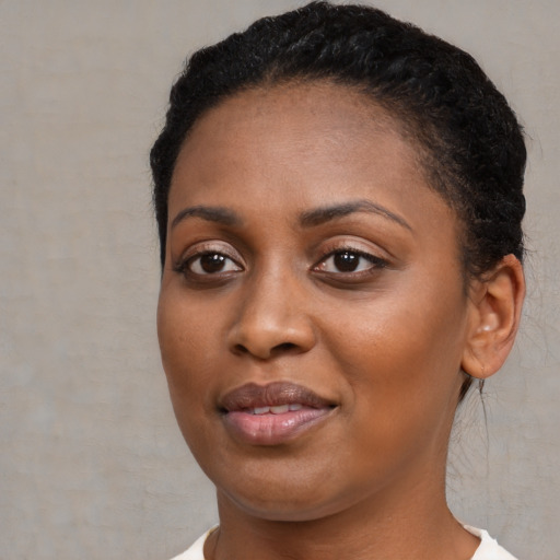 Joyful black young-adult female with short  brown hair and brown eyes