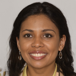 Joyful black young-adult female with long  brown hair and brown eyes