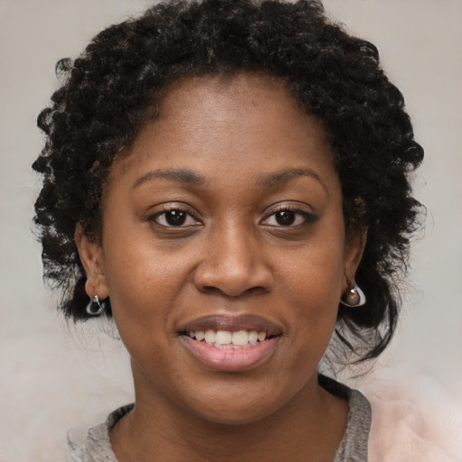 Joyful black young-adult female with medium  brown hair and brown eyes