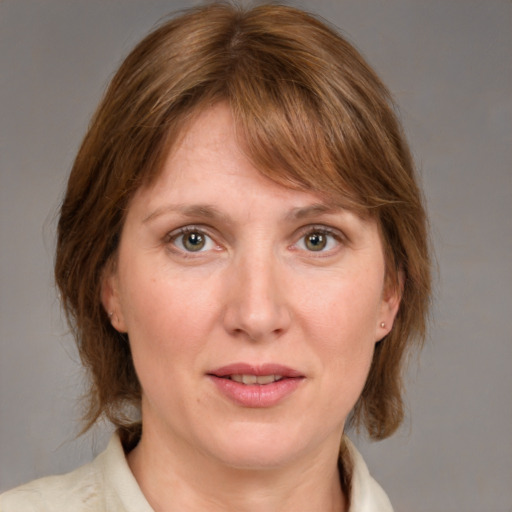 Joyful white adult female with medium  brown hair and blue eyes