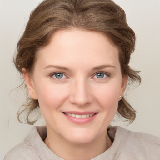 Joyful white young-adult female with medium  brown hair and blue eyes