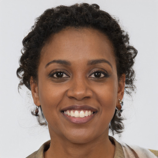 Joyful black young-adult female with short  brown hair and brown eyes