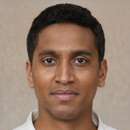 Joyful black young-adult male with short  black hair and brown eyes