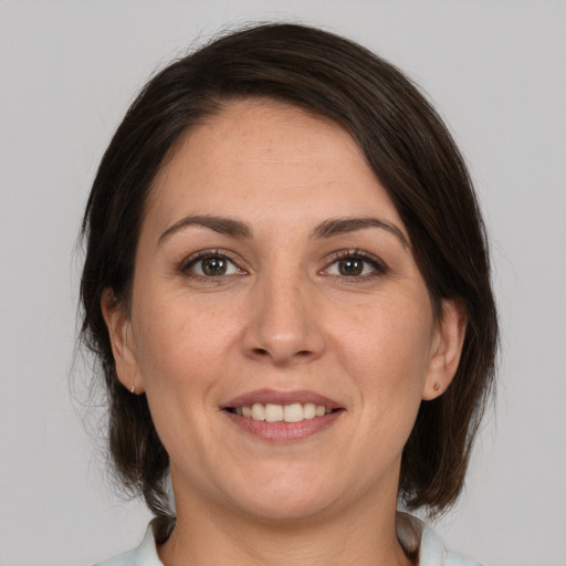 Joyful white adult female with medium  brown hair and brown eyes