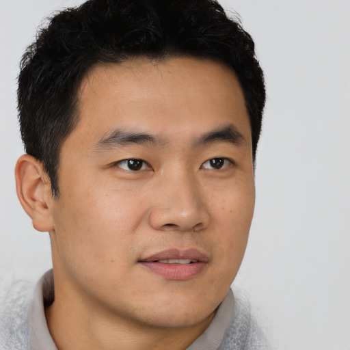 Joyful asian young-adult male with short  black hair and brown eyes