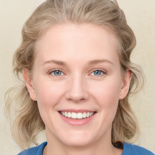 Joyful white young-adult female with medium  brown hair and blue eyes