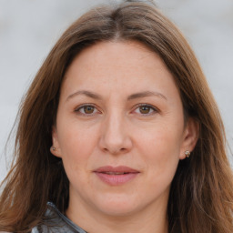 Joyful white adult female with long  brown hair and brown eyes