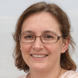 Joyful white adult female with medium  brown hair and blue eyes