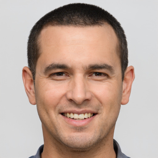 Joyful white young-adult male with short  brown hair and brown eyes