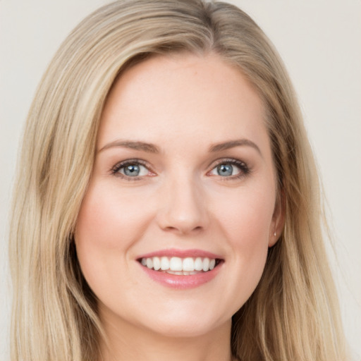 Joyful white young-adult female with long  brown hair and blue eyes