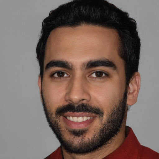 Joyful latino young-adult male with short  black hair and brown eyes