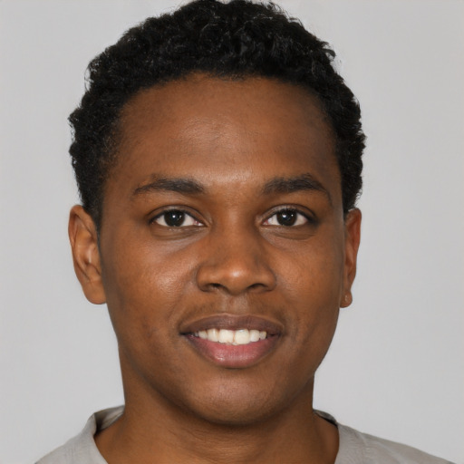 Joyful black young-adult male with short  black hair and brown eyes