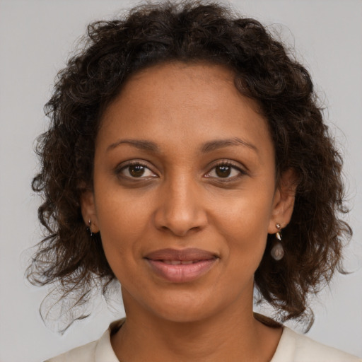 Joyful black young-adult female with medium  brown hair and brown eyes