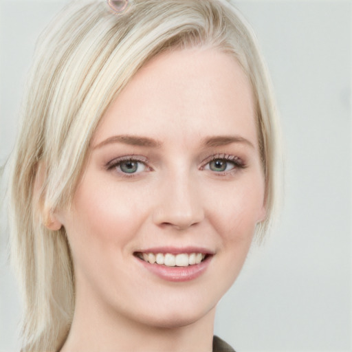 Joyful white young-adult female with long  blond hair and blue eyes