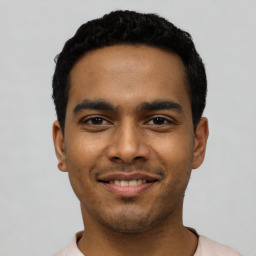 Joyful latino young-adult male with short  black hair and brown eyes