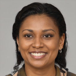 Joyful black adult female with medium  brown hair and brown eyes