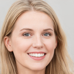 Joyful white young-adult female with long  brown hair and blue eyes