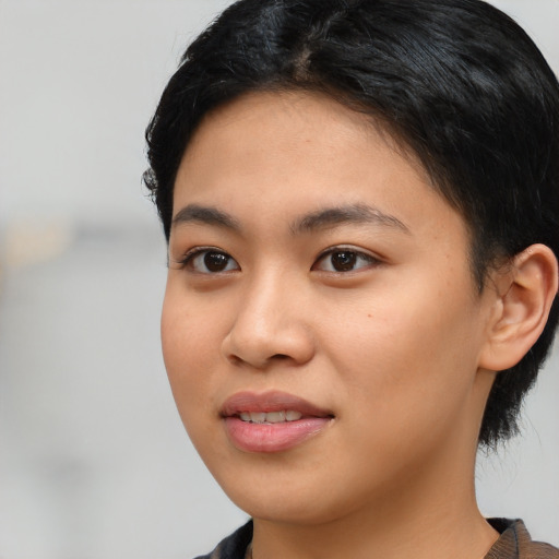 Joyful latino young-adult female with short  black hair and brown eyes