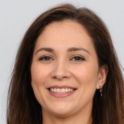 Joyful white adult female with long  brown hair and brown eyes