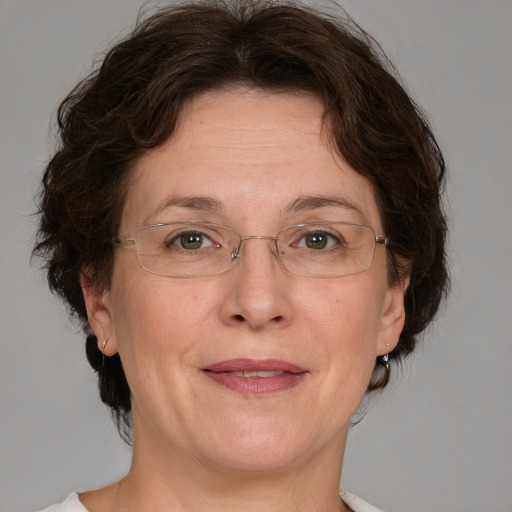 Joyful white adult female with medium  brown hair and green eyes