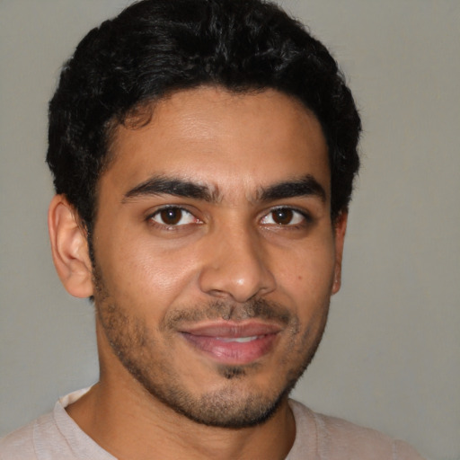 Joyful latino young-adult male with short  black hair and brown eyes