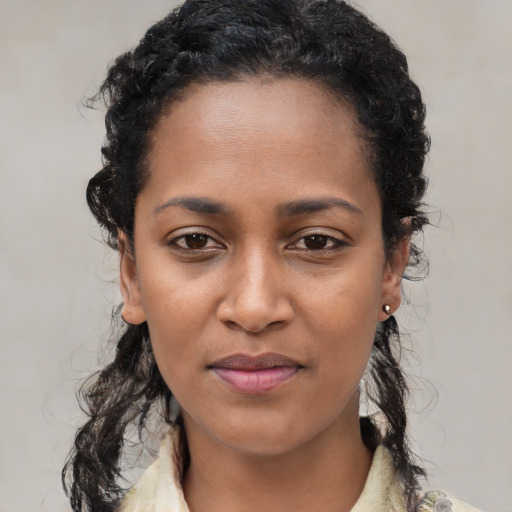 Joyful black young-adult female with medium  black hair and brown eyes