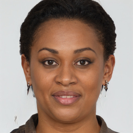 Joyful black adult female with short  brown hair and brown eyes