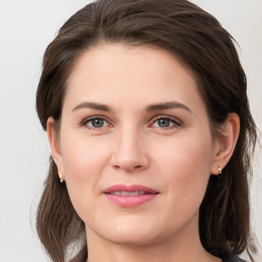 Joyful white young-adult female with medium  brown hair and grey eyes