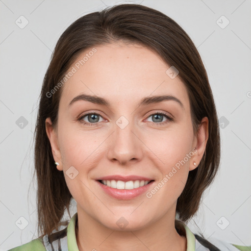 Joyful white young-adult female with medium  brown hair and grey eyes