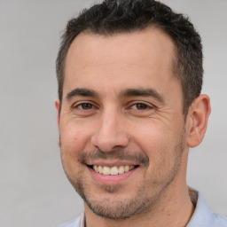 Joyful white adult male with short  brown hair and brown eyes