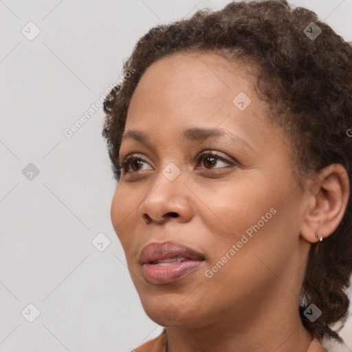 Joyful black adult female with medium  brown hair and brown eyes