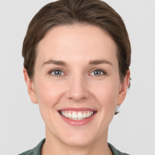 Joyful white young-adult female with short  brown hair and grey eyes