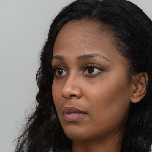 Neutral black young-adult female with long  brown hair and brown eyes