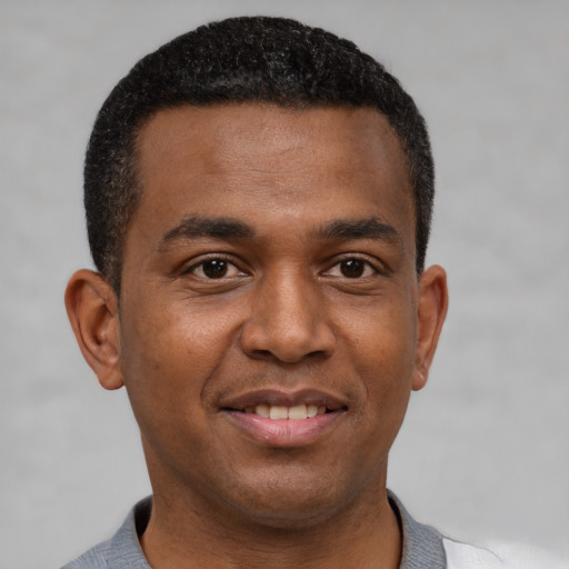 Joyful black young-adult male with short  black hair and brown eyes