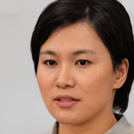 Joyful asian young-adult female with medium  black hair and brown eyes