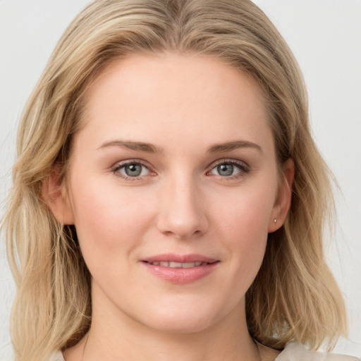 Joyful white young-adult female with long  brown hair and blue eyes