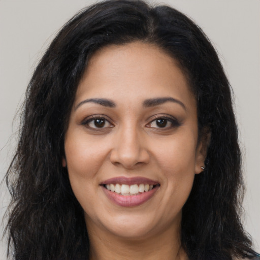 Joyful latino young-adult female with long  brown hair and brown eyes