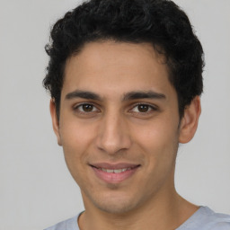 Joyful latino young-adult male with short  brown hair and brown eyes