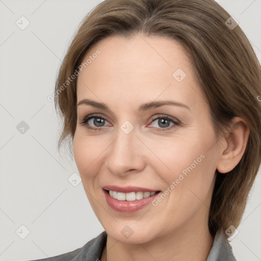 Joyful white adult female with medium  brown hair and grey eyes