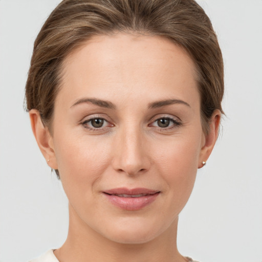 Joyful white young-adult female with short  brown hair and grey eyes