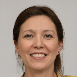 Joyful white adult female with medium  brown hair and grey eyes