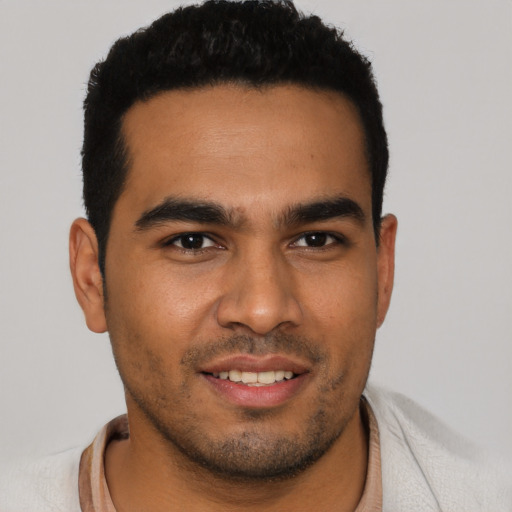 Joyful latino young-adult male with short  black hair and brown eyes