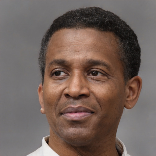 Joyful black adult male with short  black hair and brown eyes
