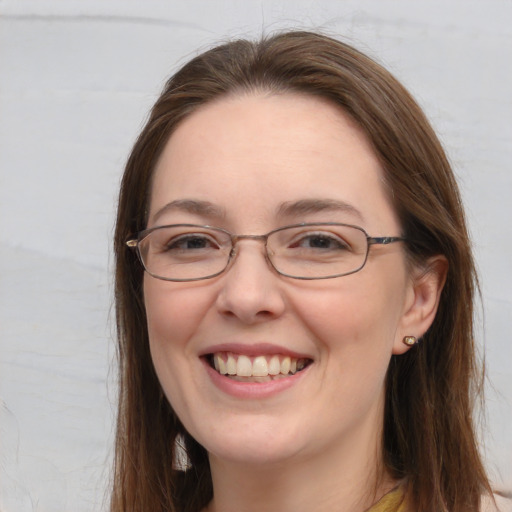 Joyful white adult female with long  brown hair and blue eyes