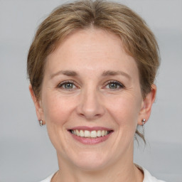 Joyful white adult female with medium  brown hair and grey eyes